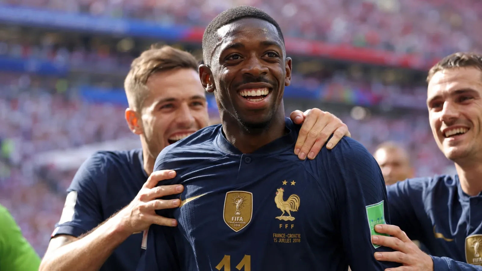 Ousmane Dembele celebrating a goal with France teammates, beaming with youthful joy.