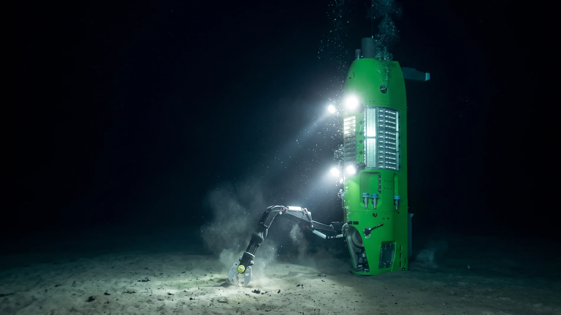 The Deepsea Challenger submarine illuminating the desolate ocean floor at the very bottom of the Mariana Trench.