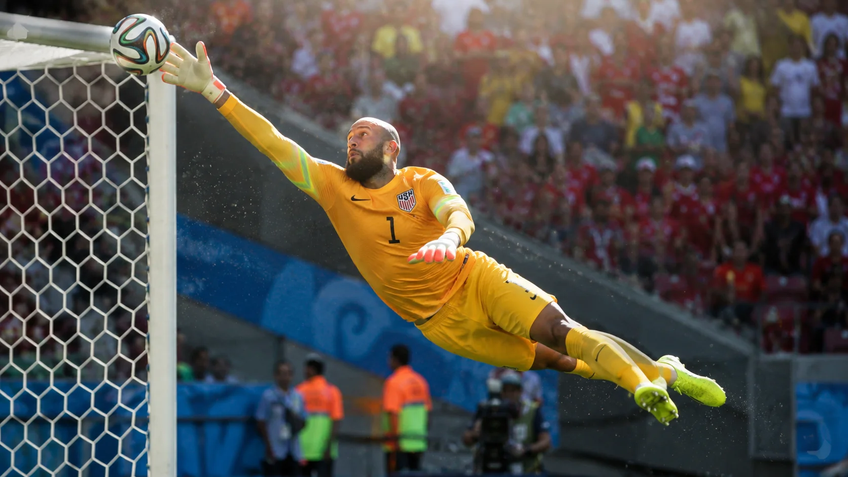A dynamic action shot of goalkeeper Tim Howard making a record-breaking save for the USMNT at the World Cup.